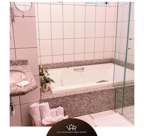 特雷斯拉瓜斯Vila Romana Park Hotel的带浴缸和盥洗盆的浴室
