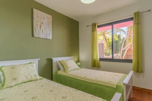 里韦拉布拉瓦Villa Rosa with private pool by HR Madeira的一间卧室设有两张床和窗户。
