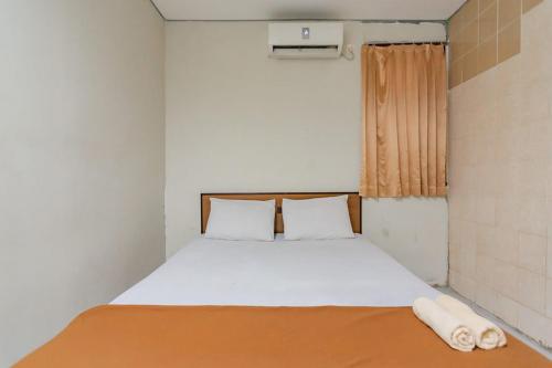 巴厘巴板Mahkota Intan Syariah Balikpapan RedPartner的一个小房间的一个床位,设有窗户