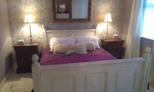 卡林福德休闲度假屋的一张带两个枕头和镜子的白色床