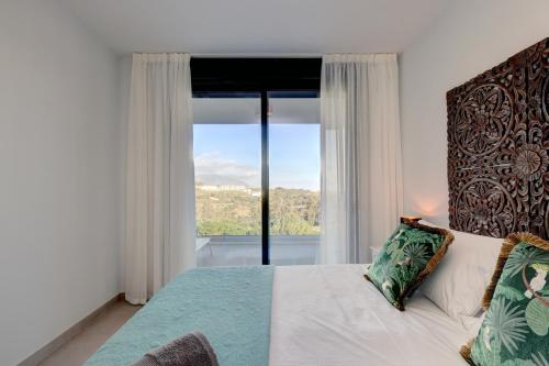 马拉加085 Modern Apartment in Trendy La Cala Golf Resort的一间卧室设有一张床和一个大窗户