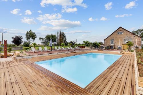 圣热尔韦昂瓦列尔Le Moulin d'Hauterive的一个带木制甲板的大型游泳池和一个房子