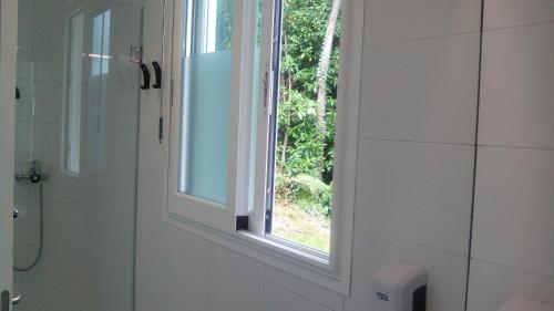 圣塞瓦斯蒂安Albergue/Auberge ULIA Youth Hostel的浴室设有淋浴旁的窗户