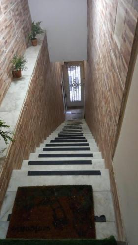 里约热内卢Quarto com suíte para mulheres的走廊上设有楼梯,有门和地毯