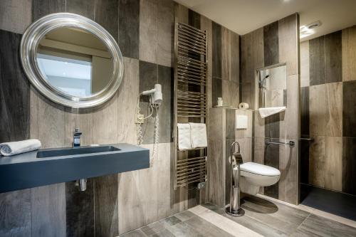 巴涅尔-德吕雄伦克鲁斯酒店的一间带水槽、卫生间和镜子的浴室