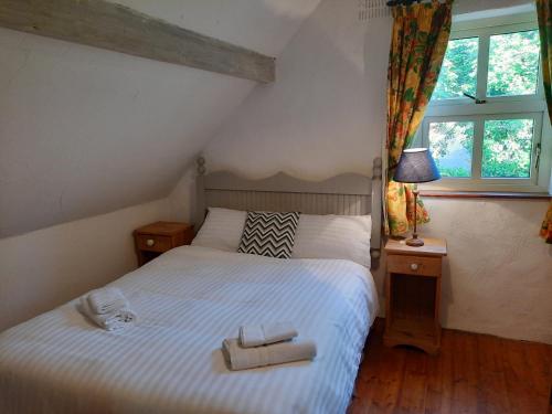 韦斯特波特Cheerful Cottage的一间卧室配有一张床,上面有两条毛巾