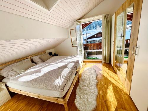 WirzweliThe Swiss Paradise 1 Penthouse apartment的一间卧室设有一张床和一个大窗户