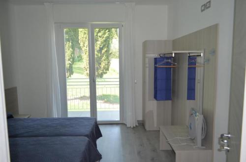 马尔切西内La Svolta Holidays的一间卧室设有一张床和一个滑动玻璃门