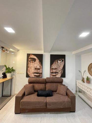 奥伦塞A Das Marías ESTUDIO的客厅里一张棕色的沙发,有两张照片