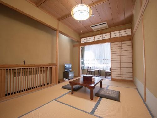 Nosegawa野迫川村酒店的客厅配有桌子和电视。