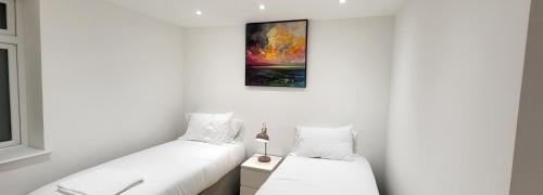 伦敦Garland Stylish Apartment 1 in Greater London的白色墙壁客房的两张床