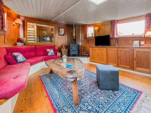 KerkdrielLuxury boat in Kerkdriel的客厅配有红色的沙发和桌子