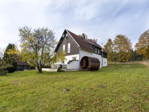 KrasliceCountry cottage with Sauna and bubble bath的一座黑白房子,院子内有桶子