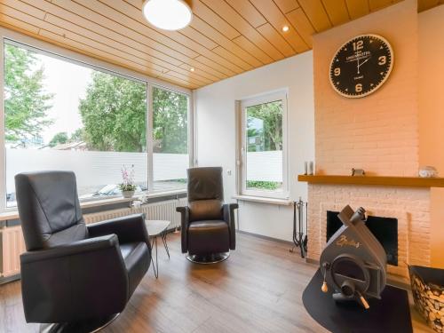 凯尔克拉Terraced house in Kerkrade with a garden的客厅配有椅子和墙上的时钟