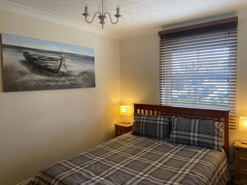 圣尼奥特Waterfront House In The Heart Of St Neots的一间卧室配有一张床,并画着一张船的照片