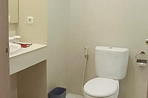 PadangsidimpuanHotel Mutiara Mitra RedDoorz的浴室配有白色卫生间和盥洗盆。