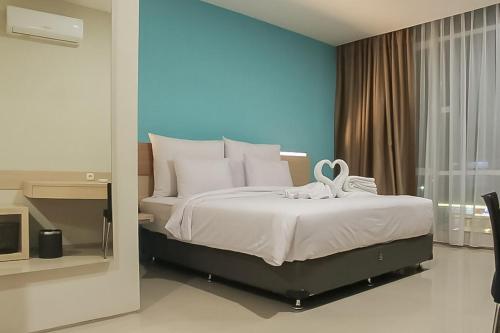 PadangsidimpuanHotel Mutiara Mitra RedDoorz的一间卧室设有一张蓝色墙壁的大床