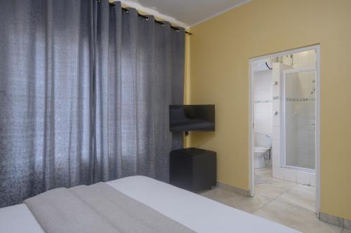 德班Ushaka Holiday Apartments的一间卧室配有一张床、一台电视和一间浴室。