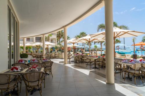 纳布勒Khayam Garden Beach Resort & Spa的一个带桌子和遮阳伞的户外用餐区