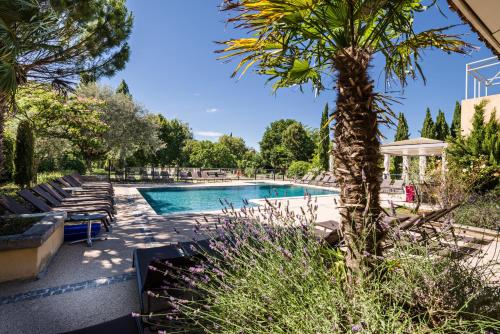 索尔格河畔利勒鲁伯隆小岛酒店的一个带椅子的游泳池,并种植了棕榈树