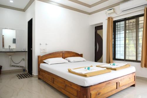 马尔万Hotel Chivla Paradise的一间卧室配有一张床,上面有两条毛巾