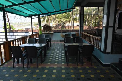 马尔万Hotel Chivla Paradise的阳台餐厅,配有桌椅