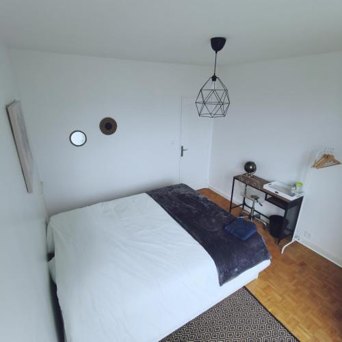 奥尔良Chambre Monde Tout confort Saint-Marceau的卧室配有一张白色的大床和一张桌子