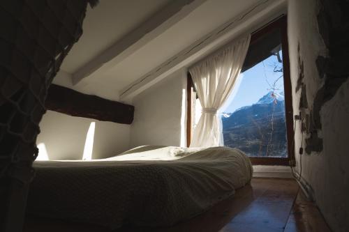 奥斯塔Cascina Des Religieuses的一间卧室设有一张床和一个大窗户