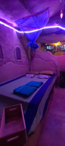 卡特勒格默Jungle river humbhaha hostel的紫色灯间的一张床位