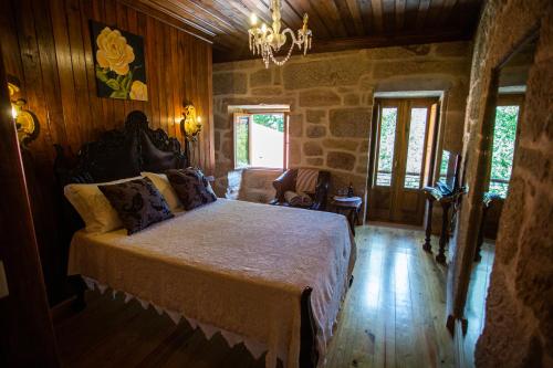 里贝拉迪佩纳Casas da Fraga 2020的卧室配有一张床铺,位于带木墙的房间内