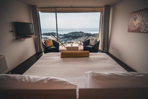 皮奇勒姆奥马尔8号酒店的一间卧室设有一张床,享有海景