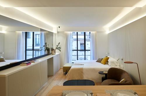 马德里60 Balconies Iconic的卧室配有一张床和一张桌子及椅子