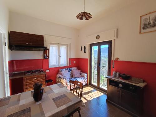 维贾内洛Tana Libera Tutti 1 Nature, Yourself, Love的一间厨房,里面设有红色的墙壁和一张桌子