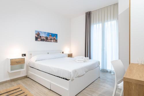 巴勒莫Palermo Blu - Multi Suite的白色卧室配有白色的床和书桌