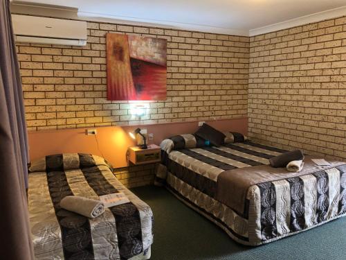 NynganAlamo Motor Inn的酒店客房带两张床和砖墙