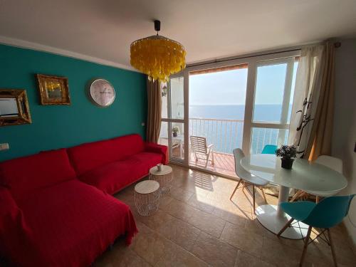 阿尔么丽亚Apartamento Almería Playa de San Miguel - Zapillo的客厅配有红色的沙发和桌子