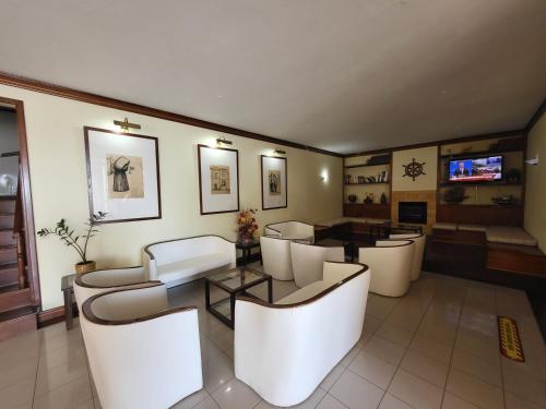 英雄港贝拉玛酒店的客厅配有白色的椅子和桌子