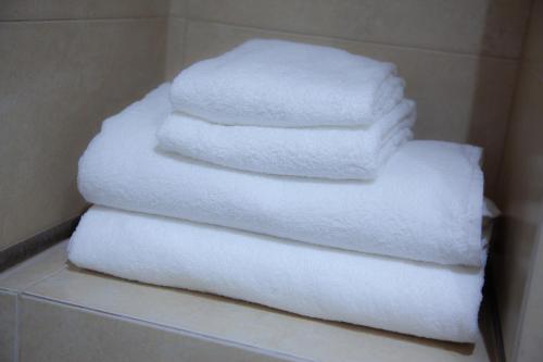 塞维利亚Noches en Triana的浴室架子上的白色毛巾堆