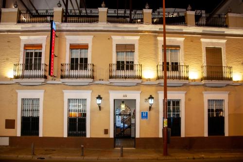 塞维利亚Noches en Triana的前面有旗帜的建筑