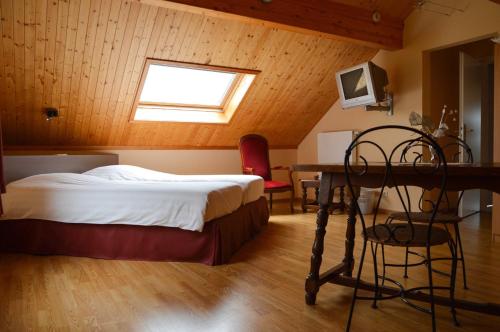 格朗当金宝别墅的一间卧室配有一张床、一张书桌和一个窗户。