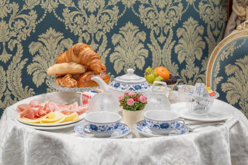 威尼斯拉洛贾住宅酒店的一张桌子,上面有盘子和杯子