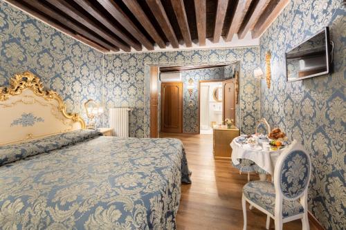 威尼斯拉洛贾住宅酒店的卧室配有一张床和一张桌子及椅子