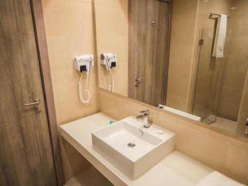 努瓦克肖特蒙诺特尔达尔巴尔卡酒店的一间带水槽、淋浴和镜子的浴室