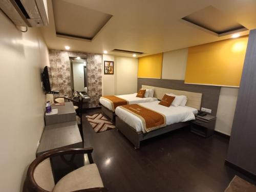 巴特那Aalcajars Inn的酒店客房设有两张床和电视。