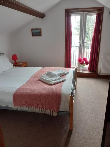Wiggenhall Saint GermansHoneysuckle Cottage的一间卧室配有一张带红色毯子的床和窗户。
