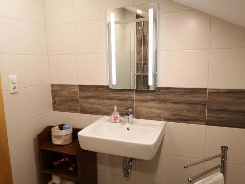 菲利普斯罗伊特Ferienwohnung - Haus Monika的浴室设有白色水槽和镜子