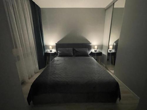 马热伊基艾Livinga 1 kambario butas centre的一间卧室配有一张床,两台桌子上放着两盏灯