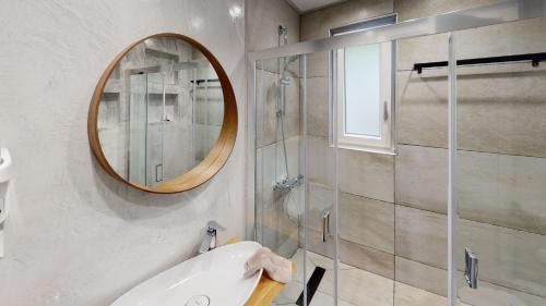 Agii SarantaYalos luxury home的带淋浴、盥洗盆和镜子的浴室