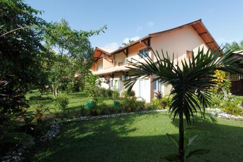 Matoury拉查米耶尔酒店的院子前有棕榈树的房子
