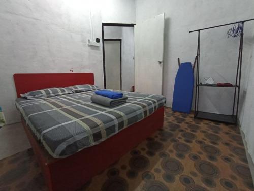 瓜拉弄宾HOME2STAY CHE MAIL 1 KUALA ROMPIN的一间卧室配有一张红色床头板的床
